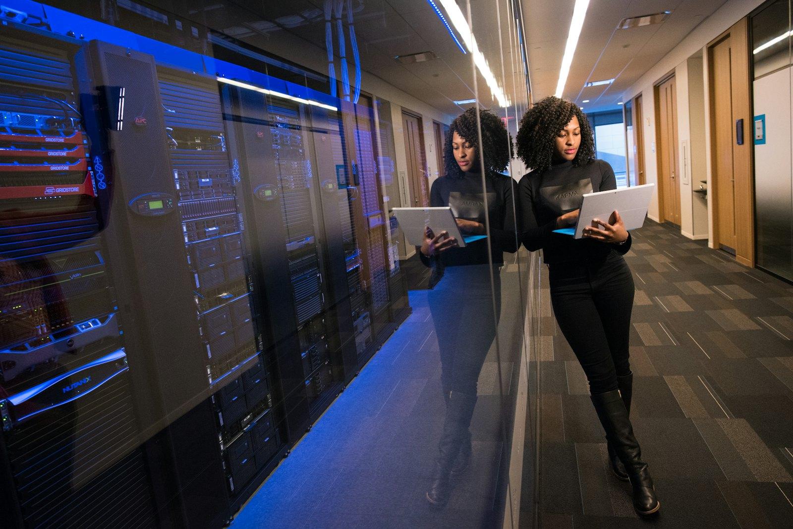 Two technologists with tablets in a server room